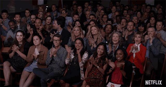a crowd of people applauding with a netflix logo behind them