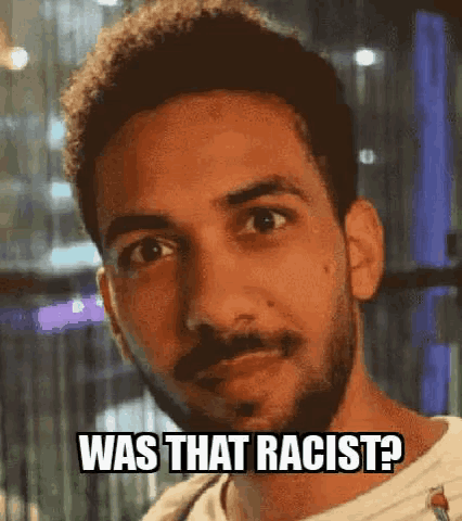 a man with a beard is making a funny face with the words was that racist written on his face .