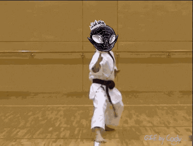 a person wearing a karate uniform with a spider man mask on their head