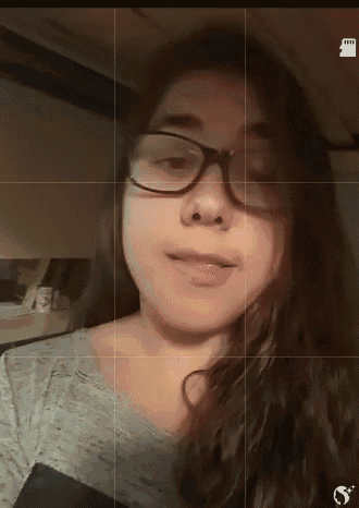 a girl wearing glasses looks at the camera with a grid around her face