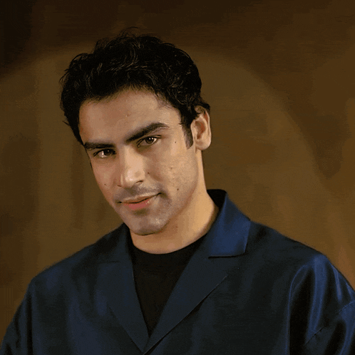 a man wearing a blue shirt is clapping his hands together