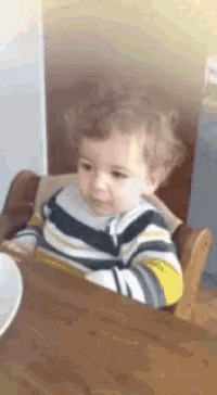 a baby is sitting in a high chair and looking at something
