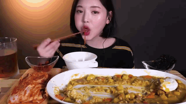a woman is eating a large plate of food