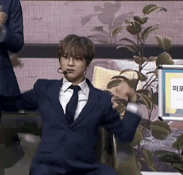 a man in a suit and tie is sitting in a chair