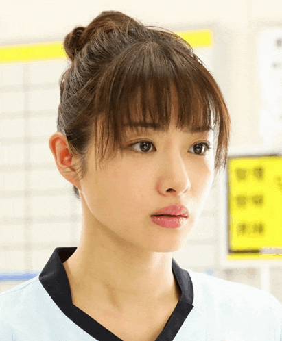 a close up of a woman 's face with a yellow sign behind her