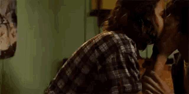 a man and a woman are kissing in a room .