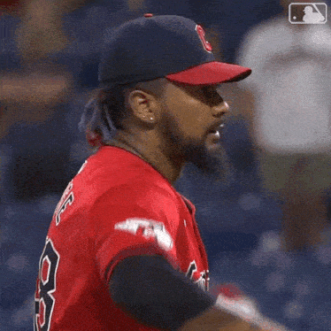 a baseball player wearing a guardians jersey and hat