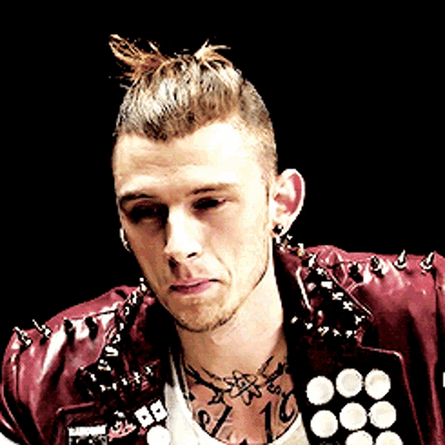 a man with a tattoo on his chest has a red jacket with spikes on the shoulder