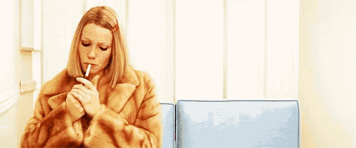 a woman in a fur coat sits on a blue chair