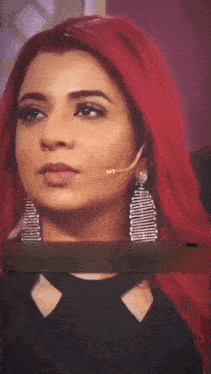 a woman with red hair is wearing a black shirt and earrings