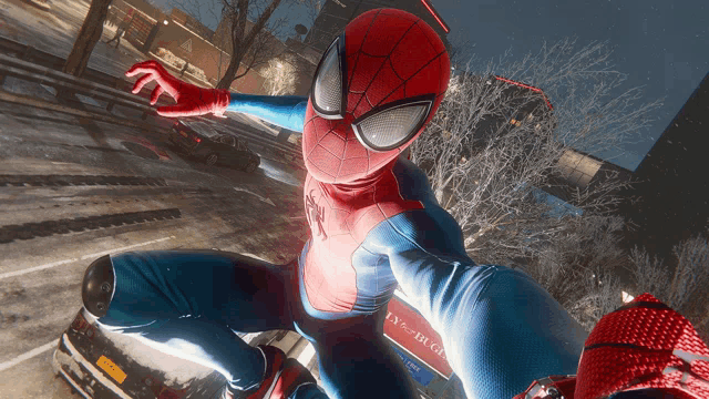 a person in a spiderman costume is taking a selfie in front of a new york state license plate