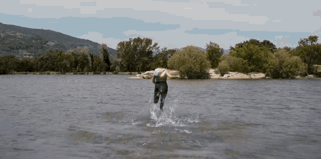 a person is jumping into a body of water