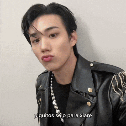 a young man wearing a black leather jacket with the words piquitos solo para xiare written below him