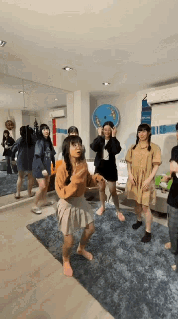 a group of girls dancing in front of a mirror