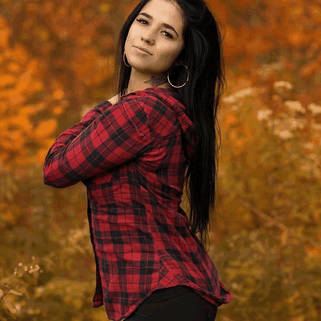 a woman wearing a plaid shirt with a hood