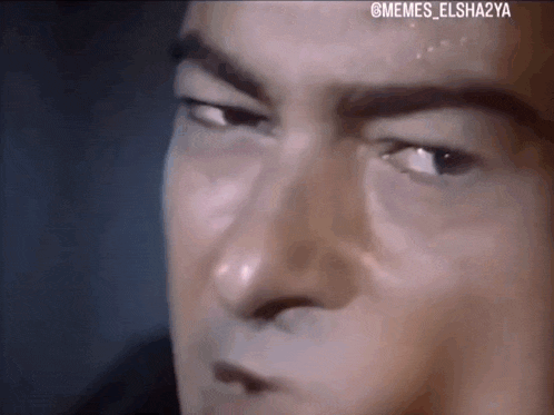 a close up of a man 's face with his eyes closed and sweat on his forehead .