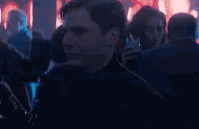 a man in a blue shirt is in a crowd of people