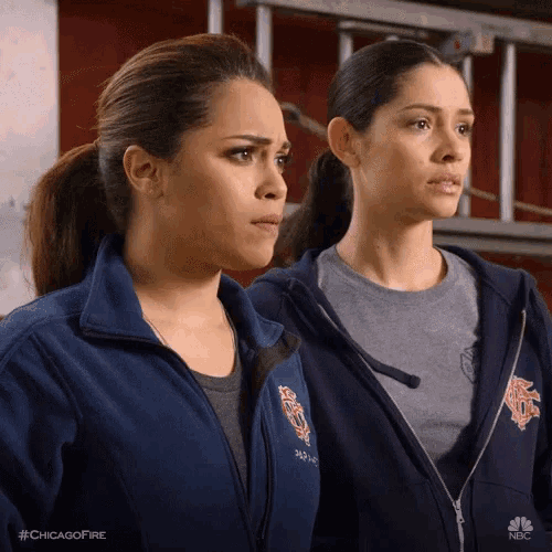 two women are standing next to each other wearing jackets that say chicago fire on them