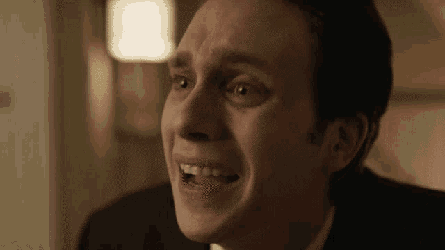 a man in a suit is making a funny face