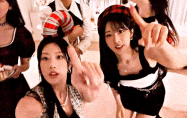 a group of women are posing for a picture and one of them is pointing at something
