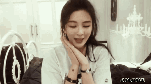 a woman is sitting on a bed with her eyes closed and the words sunbinnie on the bottom