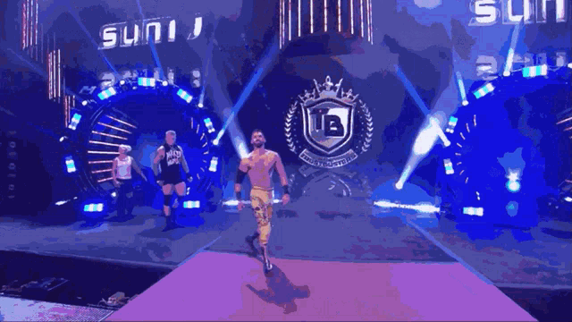 a wrestler wearing a shirt that says naked body walks on a purple carpet