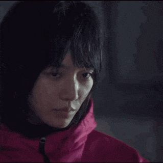 a close up of a woman wearing a pink jacket with a hood .