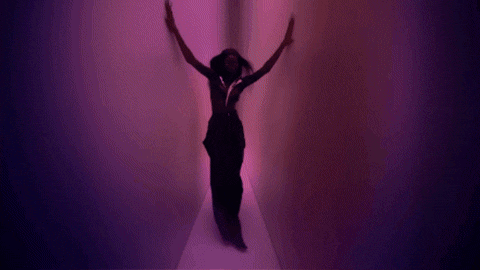 a silhouette of a woman is surrounded by purple glowing lights