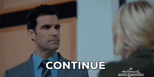a man in a suit and tie is talking to a woman in a hallway and the word continue is on the screen .