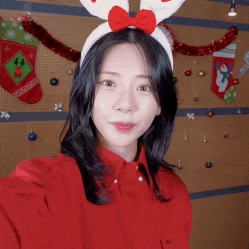 a woman wearing bunny ears and a red shirt takes a selfie