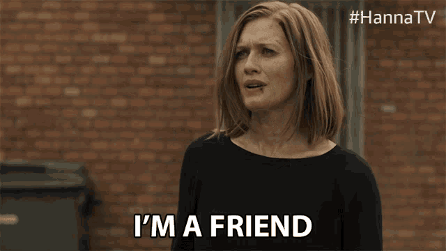 a woman is saying i 'm a friend in front of a brick wall