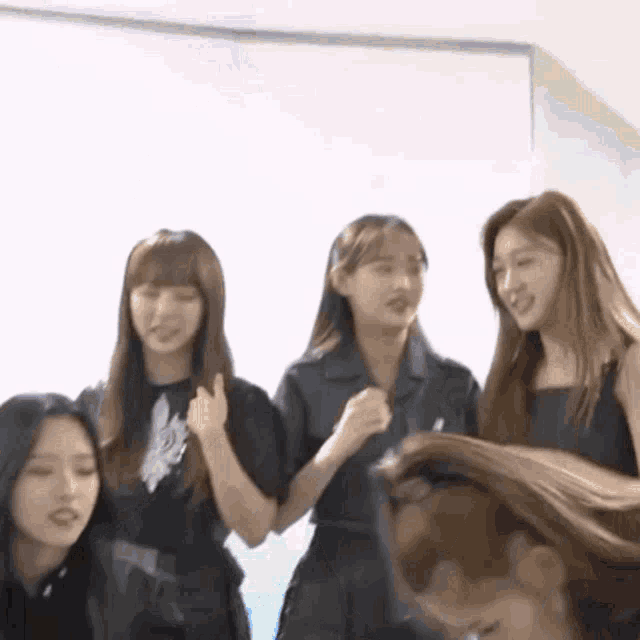 a group of women are standing next to each other and one of them is holding another woman 's hair .