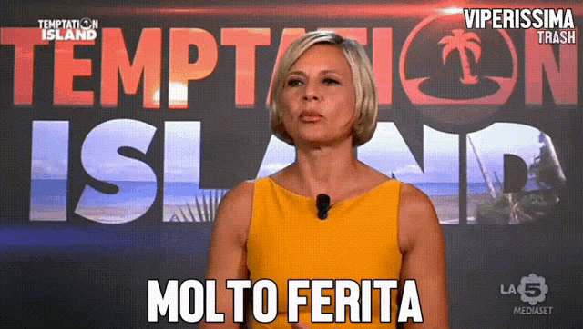 a woman in a yellow dress stands in front of temptation island