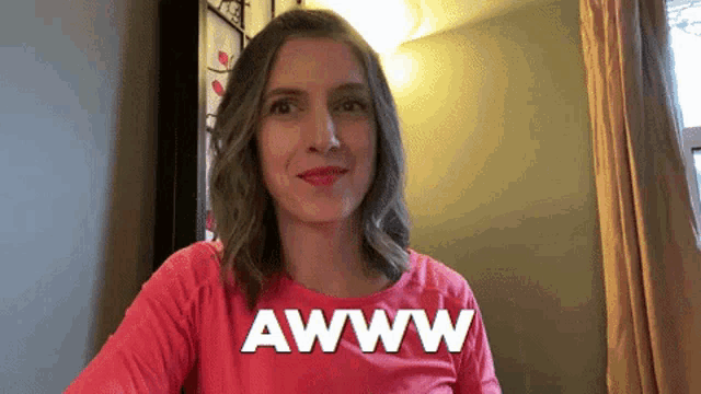a woman in a red shirt is making a funny face and says awww