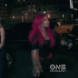 a woman with bright pink hair is standing in front of a sign that says pay here .