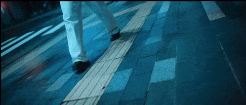 a person walking on a sidewalk with a diagonal line