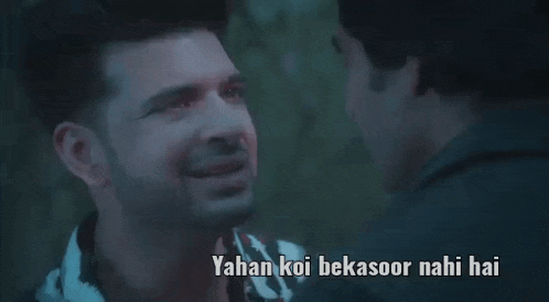 two men are talking to each other in a dark room with a caption that says yahan koi bekasoor nahi hai .