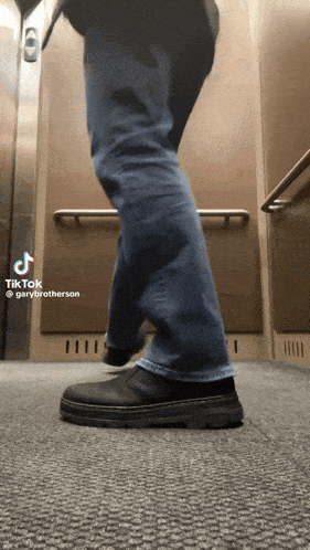 a person 's legs are shown in an elevator with a tiktok by gary brotherson