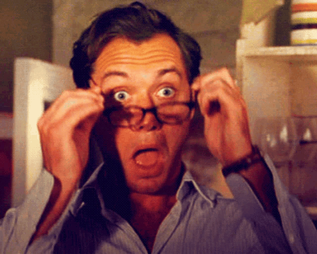 a man wearing glasses makes a surprised face