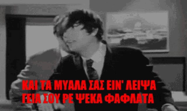 a black and white photo of a man in a suit and tie with the words kai ta myala sas ein aeypa