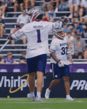 two boston lacrosse players celebrate a goal during a game