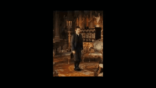 a man in a suit stands in a living room