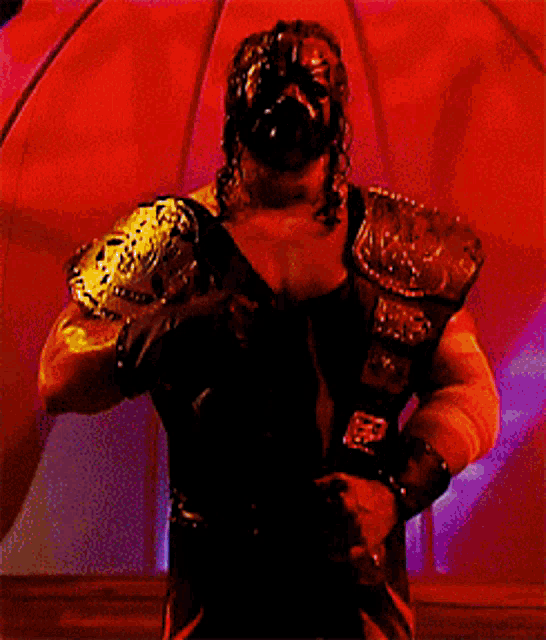 a man in a mask is standing in front of a window with a red light behind him