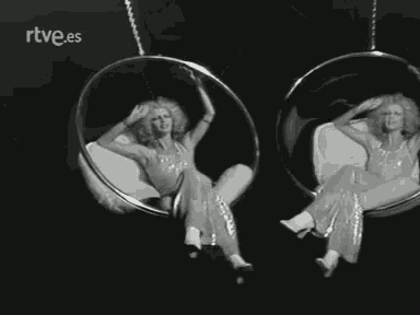 a woman is sitting in a bathtub looking at herself in the mirror .