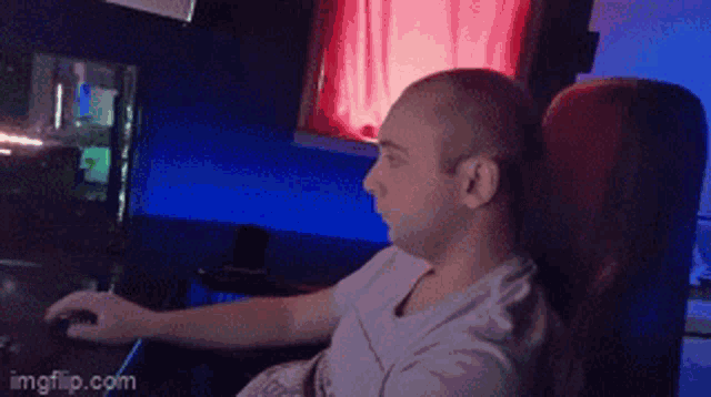 a man sitting in a chair using a computer mouse