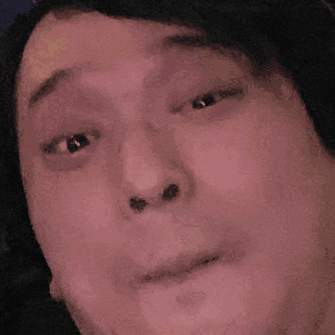 a close up of a person 's face with a hat on making a funny face .