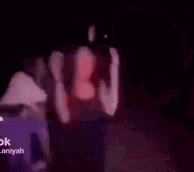 a close up of a person 's face in a dark room in a blurry photo .