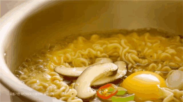 a bowl of noodles with vegetables and an egg in it