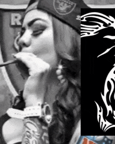 a woman in a raiders hat is smoking a cigarette .