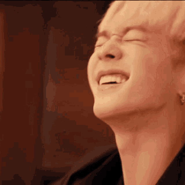 a close up of a person 's face with their eyes closed and a smile on their face .
